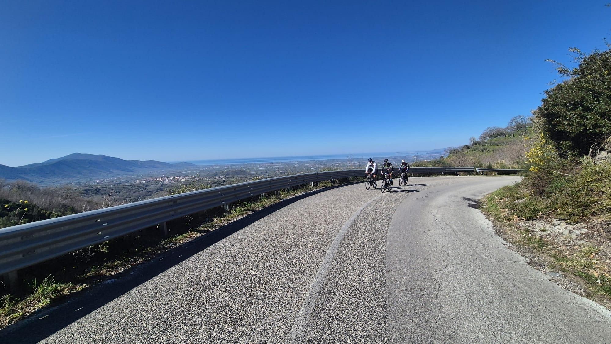 Due ciclisti in salita su una strada di montagna, aprile 2026